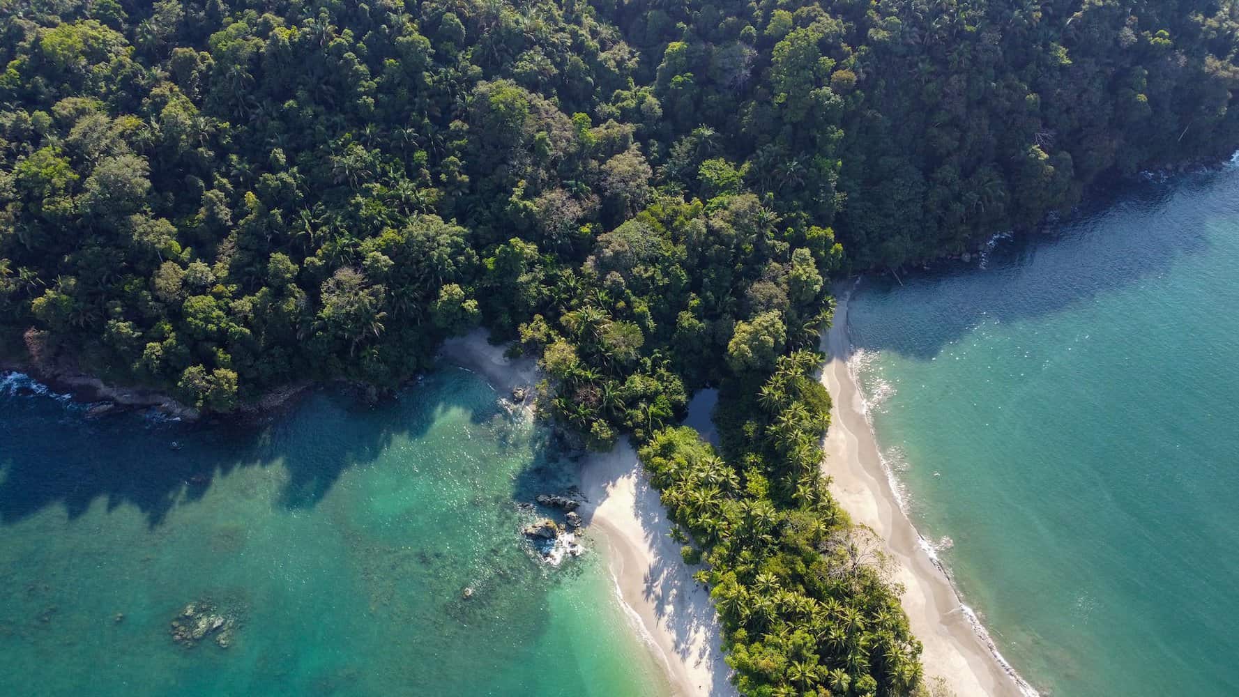 an aerial shot of the manuel antonio beach in costa rica slow living lifestyle