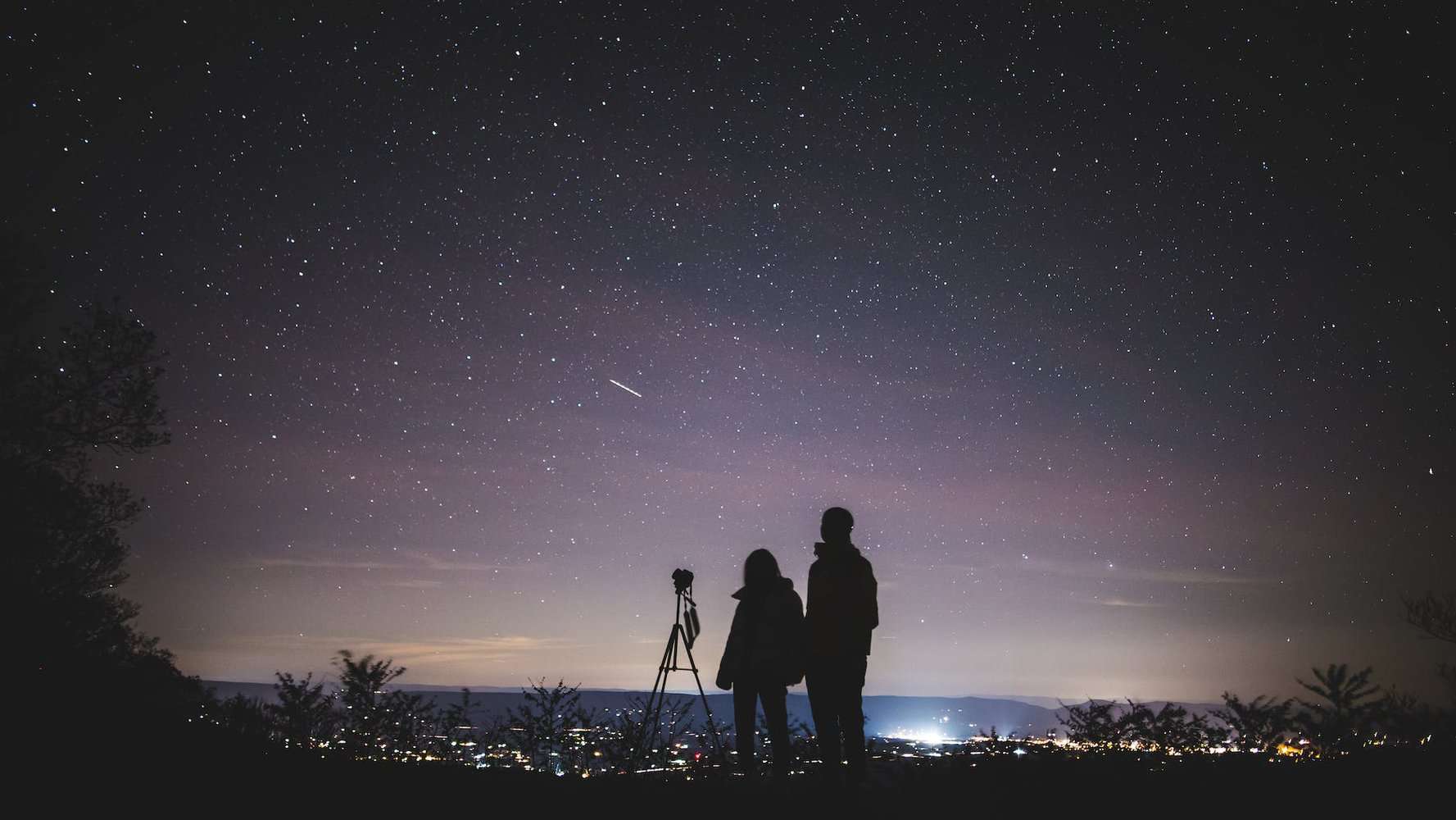 silhouette of two persons stargazing, questioning life. spiritual pantheism.
