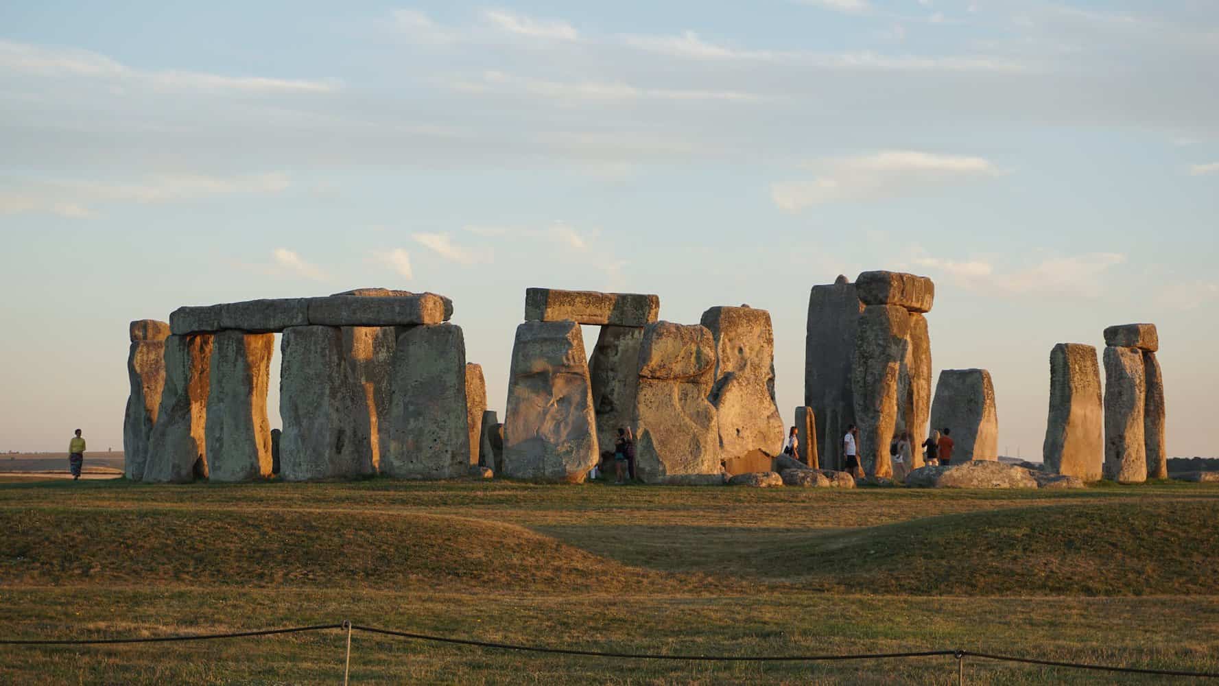 photo of people standing near stonehenge. One of the Uks pilgrimage routes.