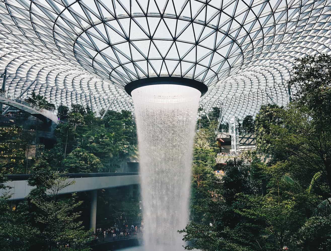 water falling from glass ceiling. Singapore Airport, Indoor Waterfall into thick jungle scene. making singapore one the best travel destinations for design lovers