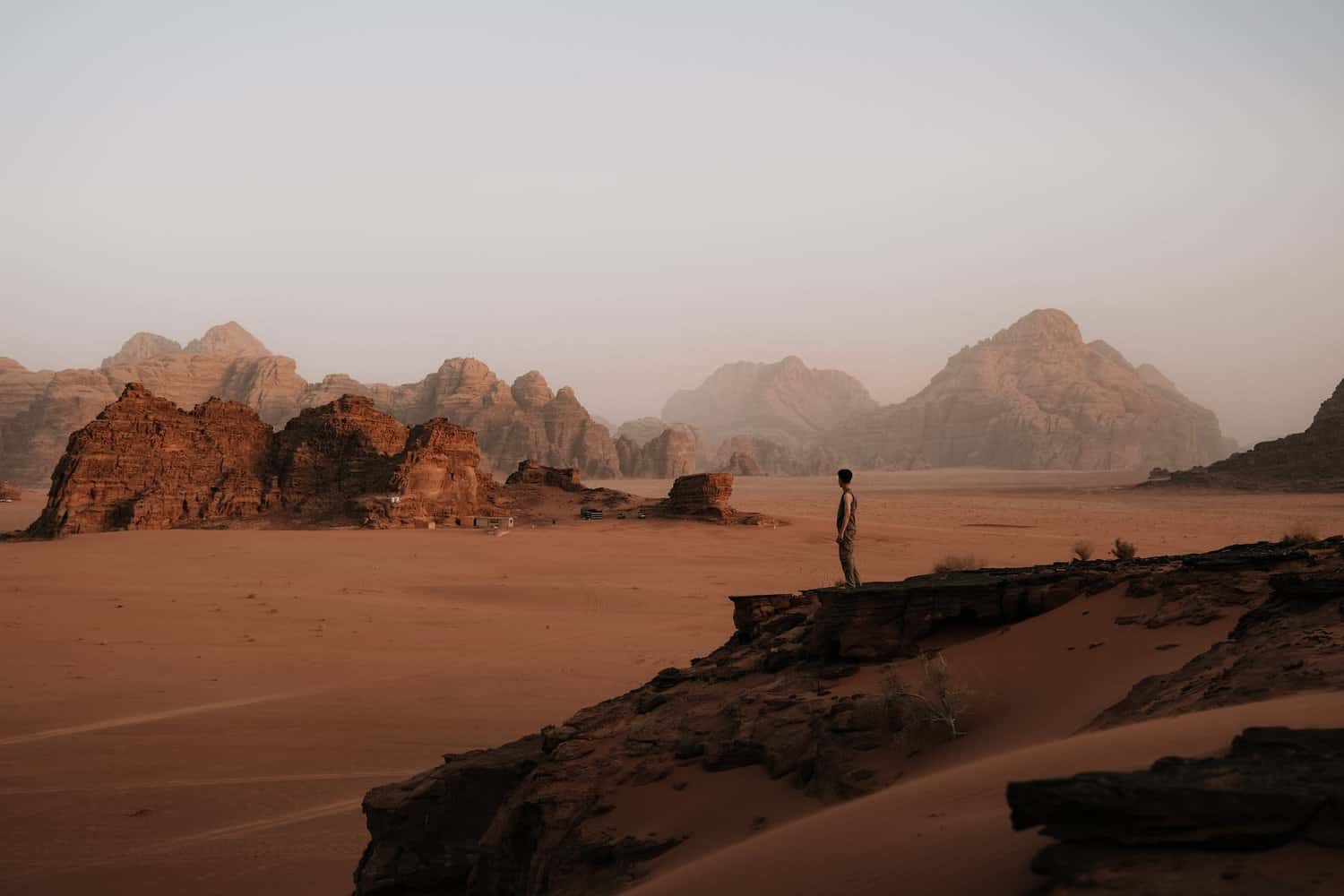 man sitting on a rock in the wadi rum valley in jordan