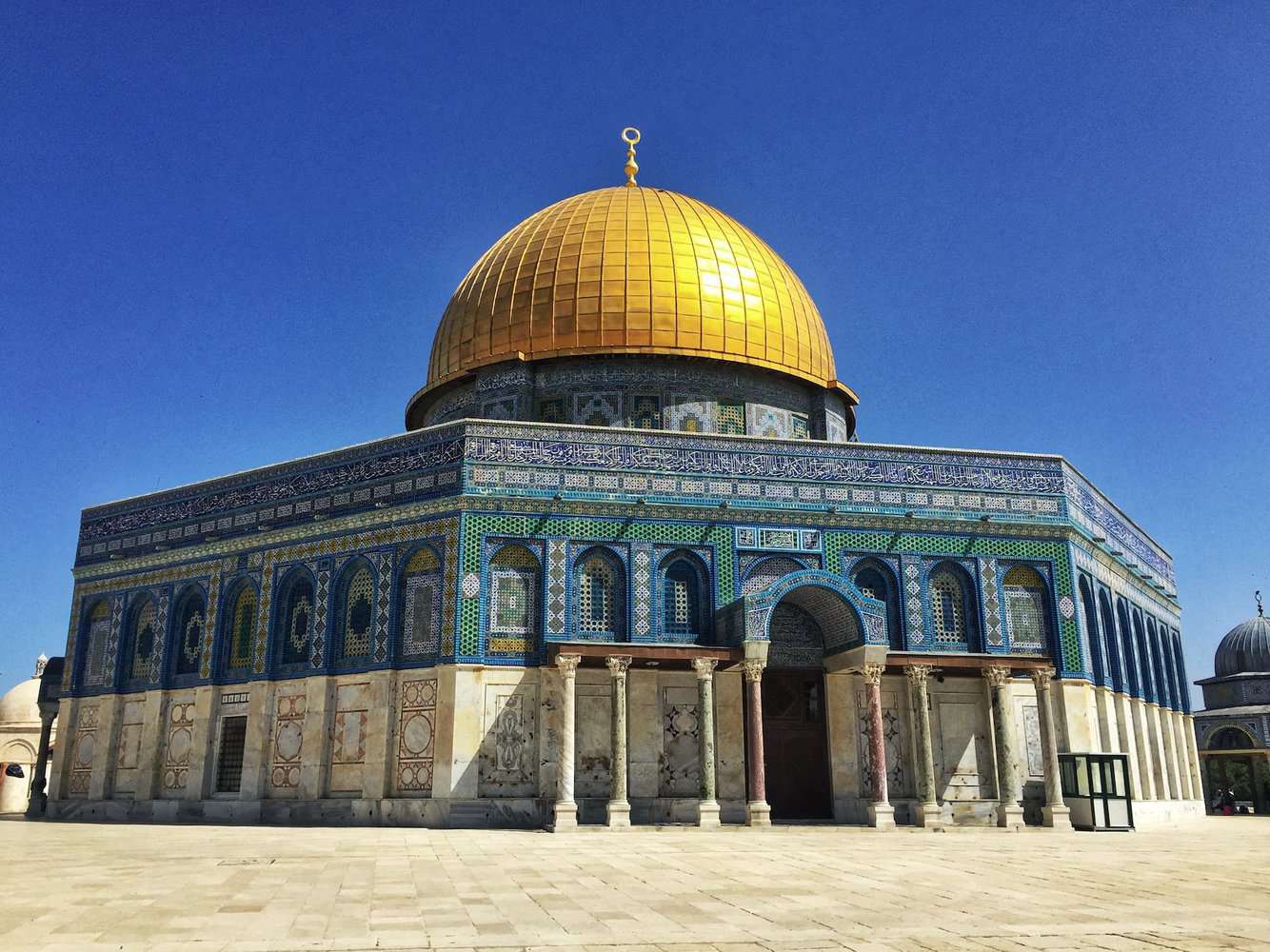 a blue tiled gold domed mosque