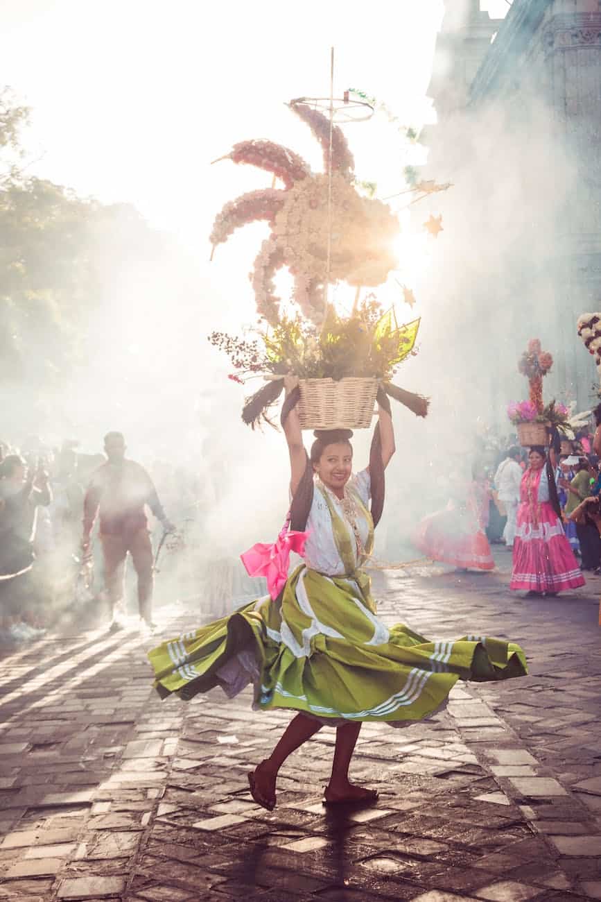 mexican woman dancing with a flower basket on her head
