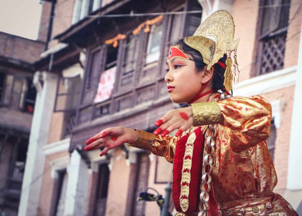 woman wearing yellow and red traditional dress dancing near building