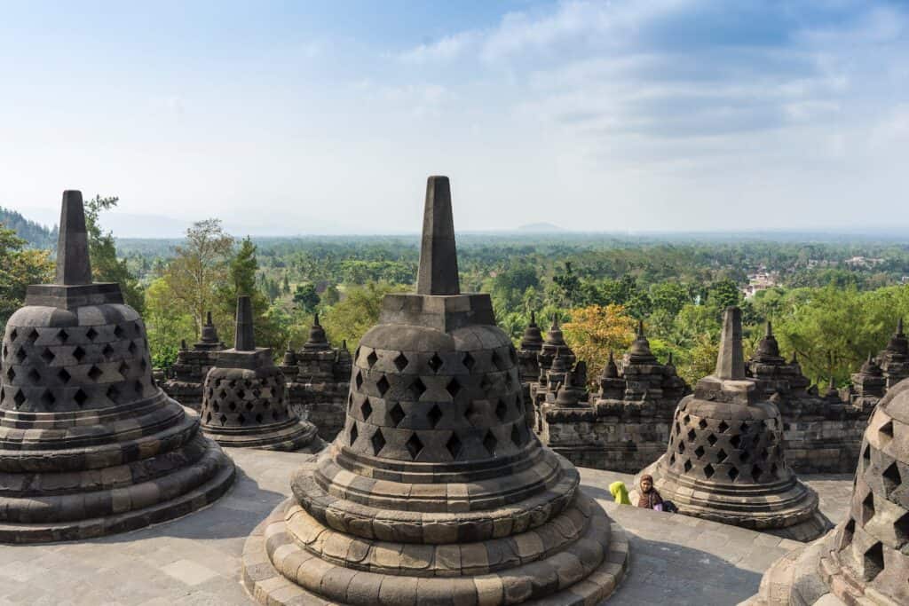Borobudur Temple during Daytime huge stone stupas that look like bells on a temple